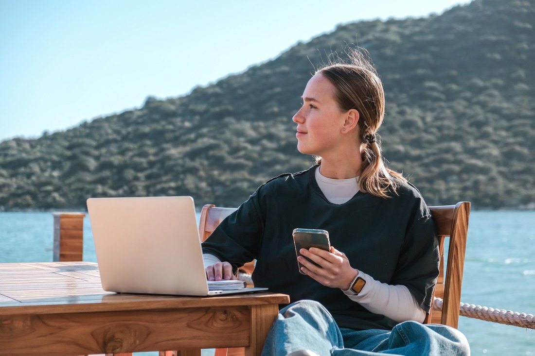 Woman working remotely near a beach