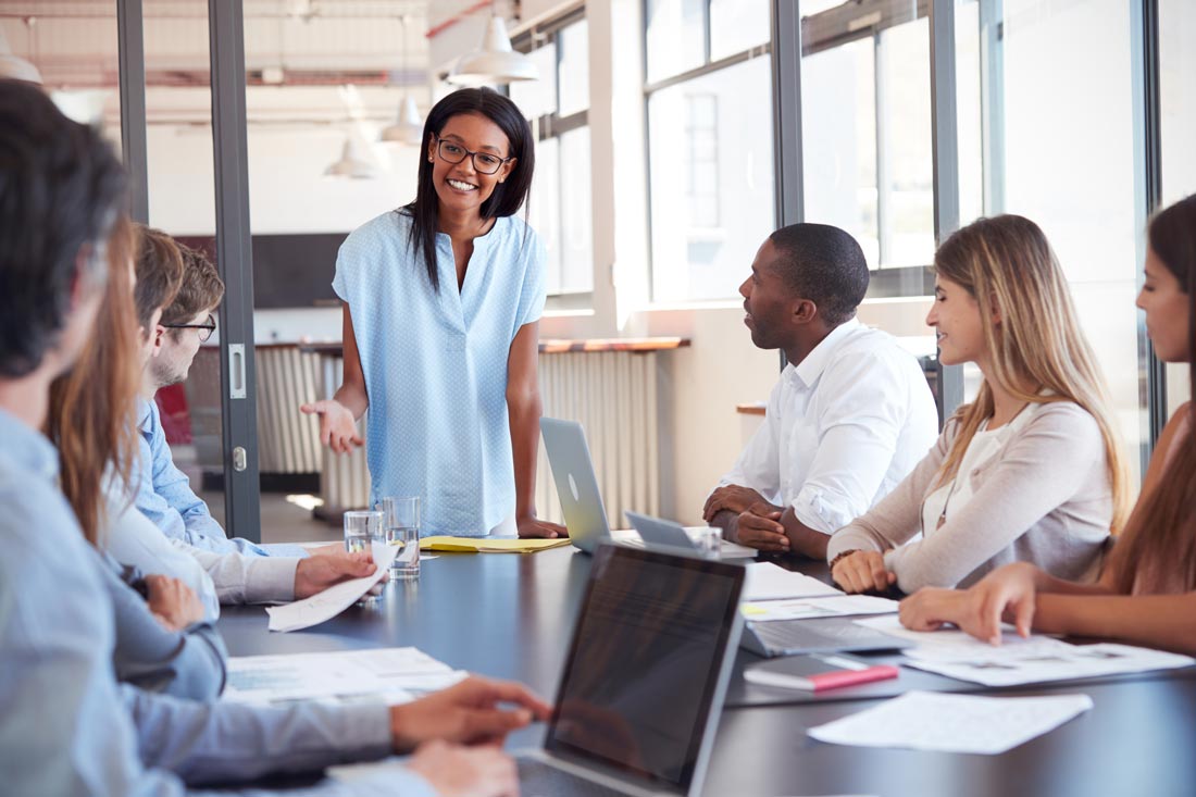 Smiling boss speaking to her employees and building trust as a leader